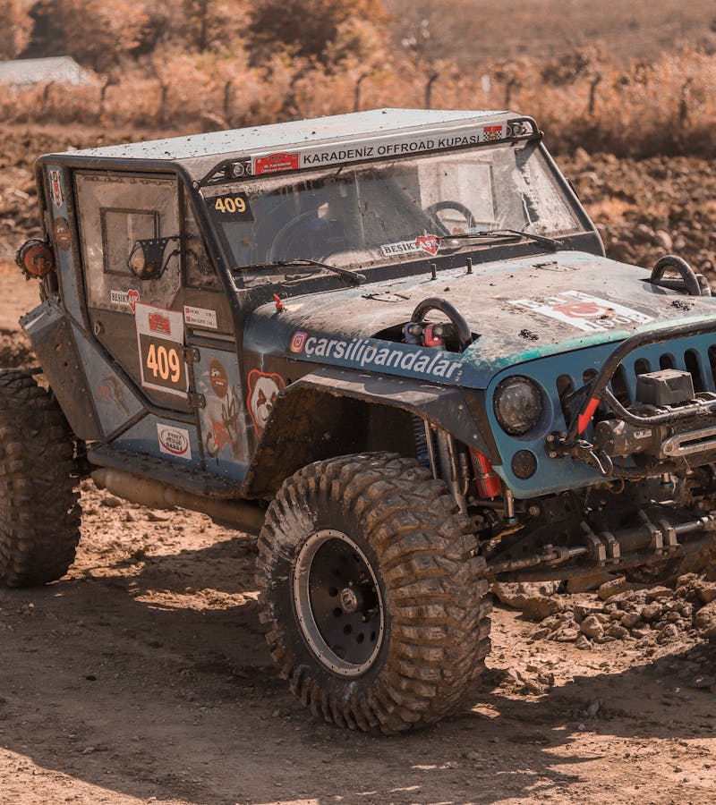 Off-road UTV driving through muddy terrain during an off-road event