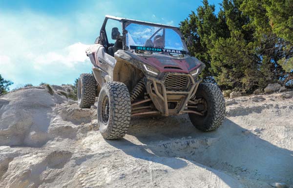 UTV equipped with Recon Trail tires driving over rocky off-road terrain